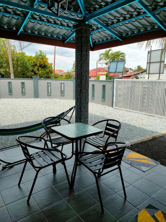 a table and two chairs sitting under an umbrella at DARUL AMAN Homestay Jitra in Jitra