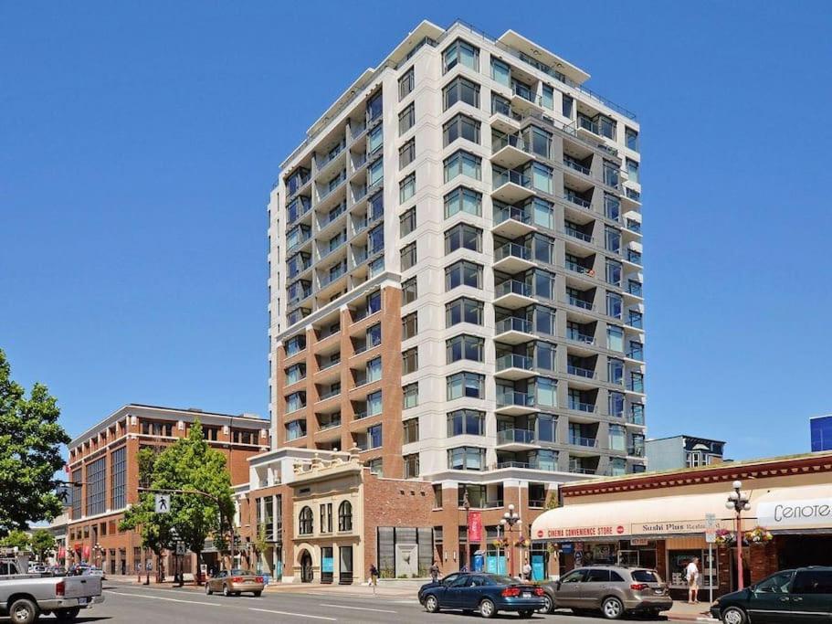 a tall white building on a city street with cars at Modern 2 bedroom ocean views Victoria downtown free parking in Victoria