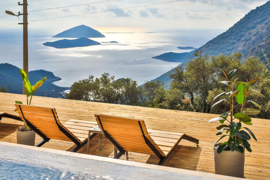 Una piscina con dos sillas y vista a las montañas. en Notos Club, en Kas