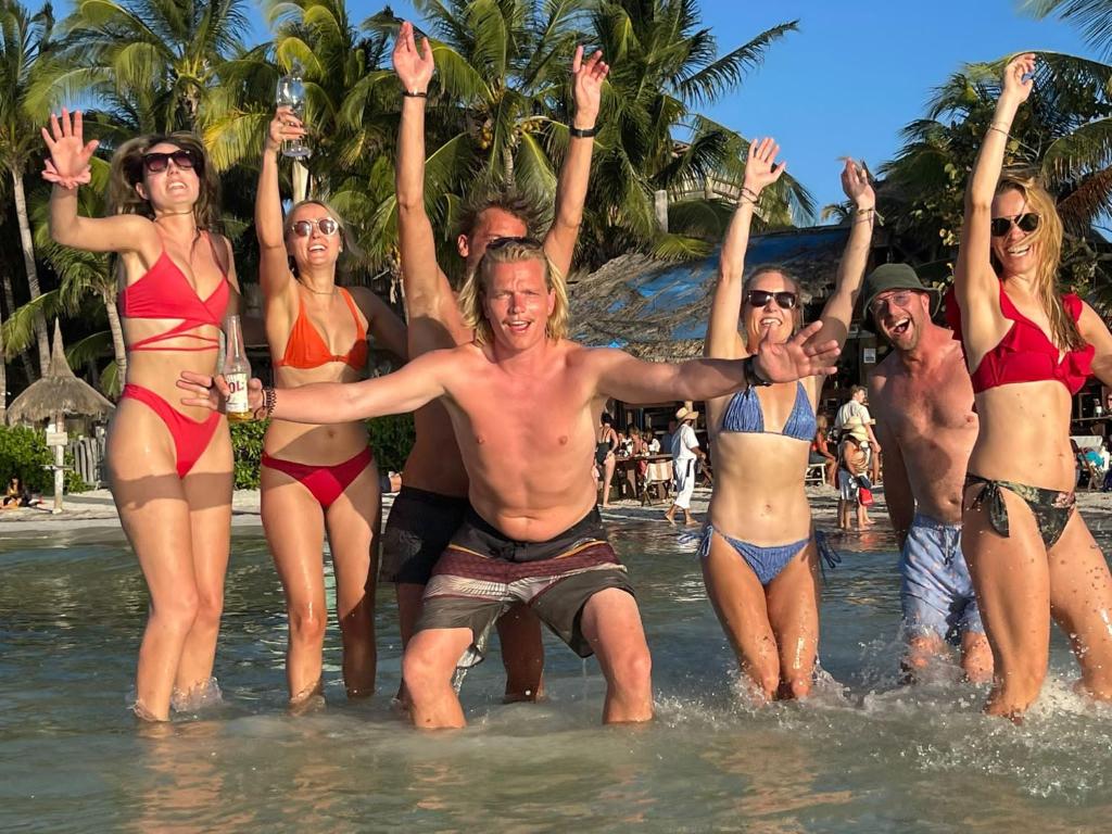 a group of people in the water at the beach at Hotel and Beach Club Escape Holbox in Holbox Island