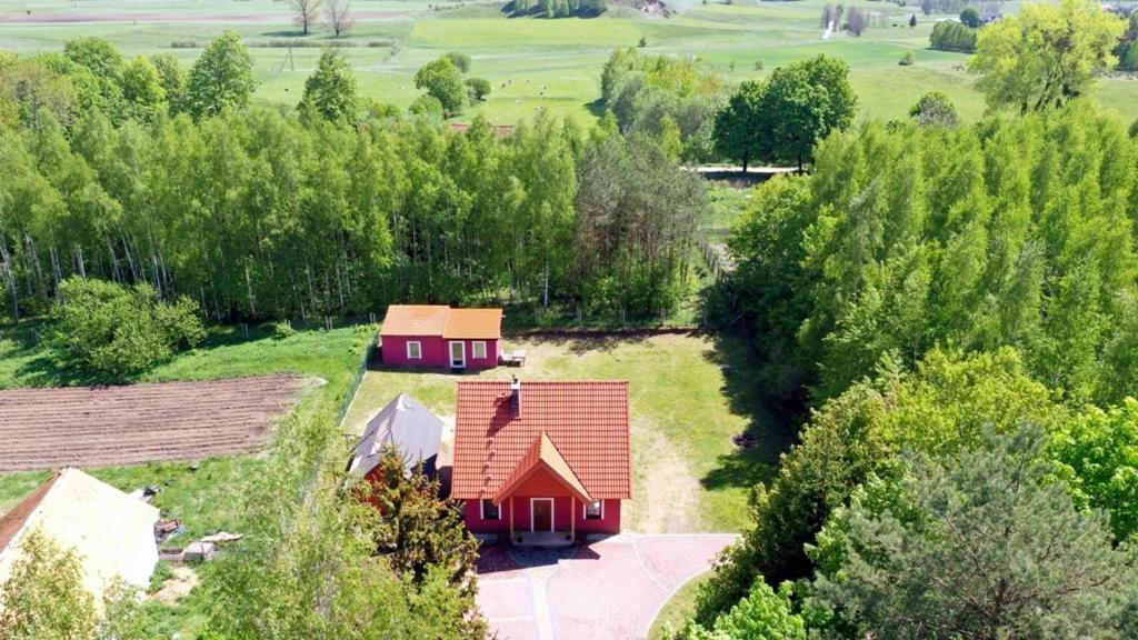 an aerial view of a red house in a field at Domek letniskowy w lesie 6 -7 osób in Wydminy