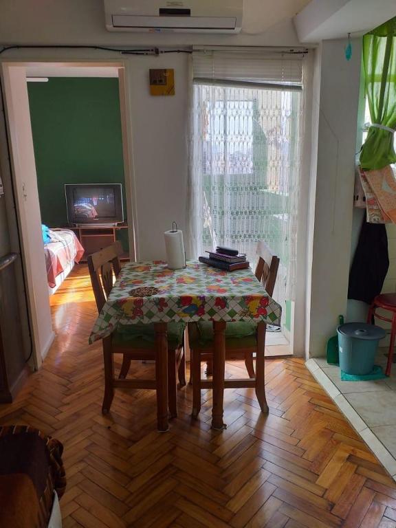 a dining room with a table and chairs and a television at Carlos Calvo in Buenos Aires