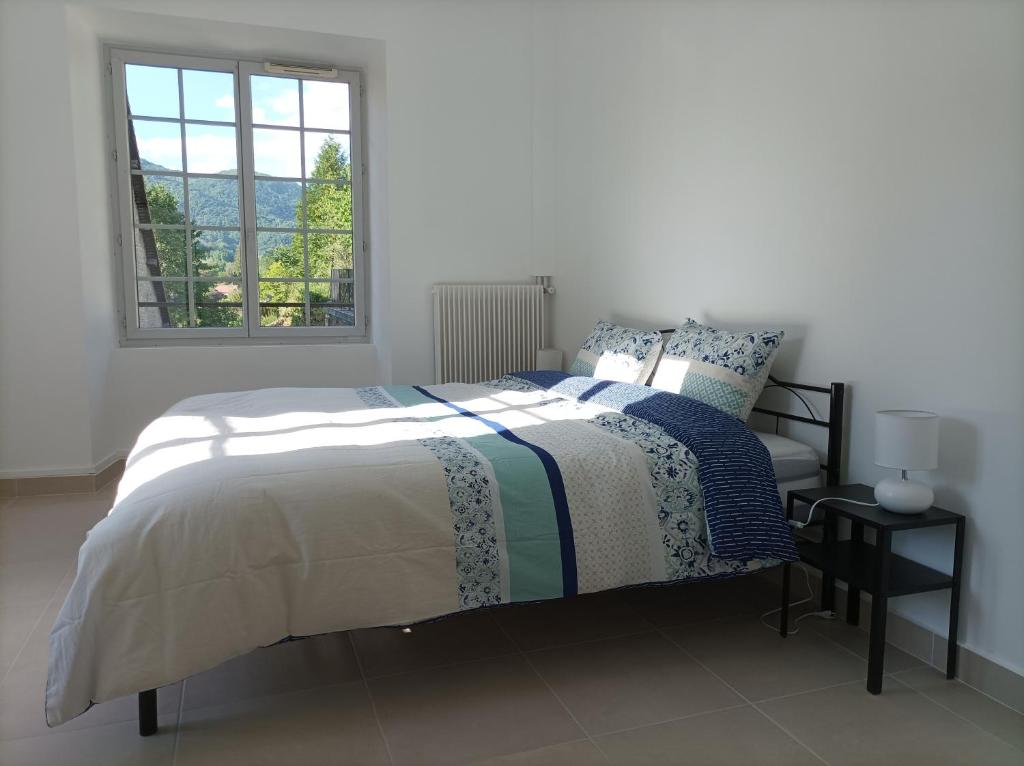 een witte slaapkamer met een bed en een raam bij O'Couvent - Appartement 125 m2 - 5 chambres - A524 in Salins-les-Bains
