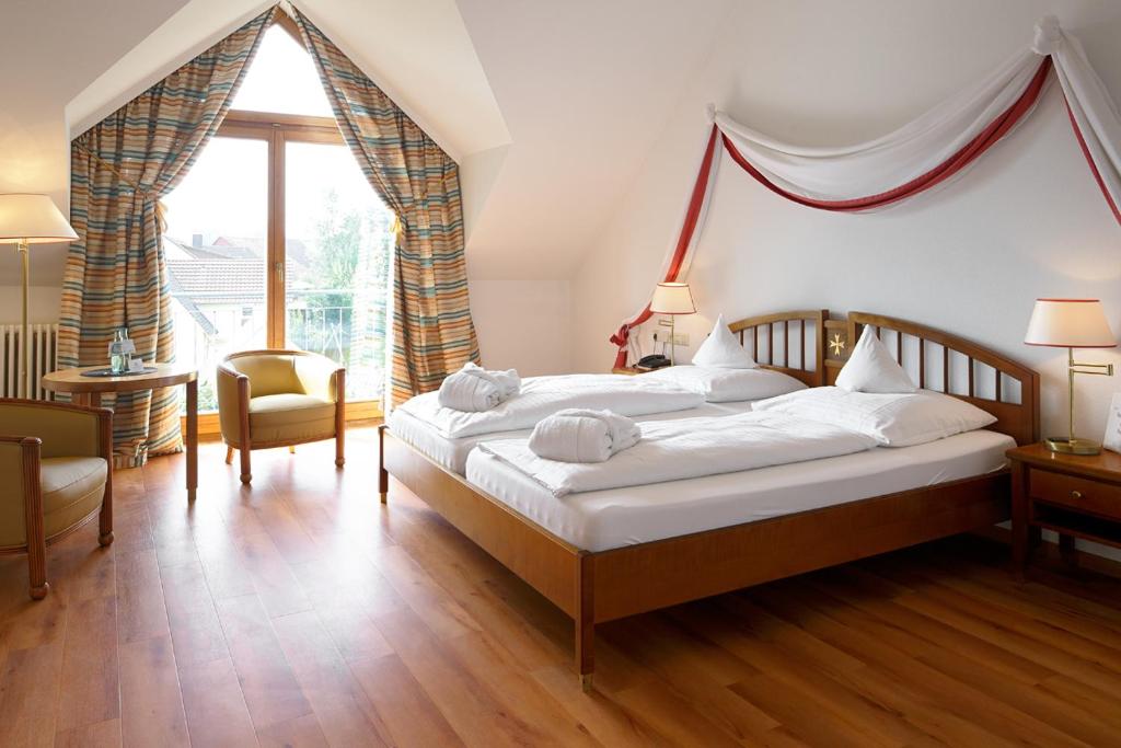 a bedroom with a bed and a large window at Romantik Hotel Johanniter-Kreuz in Überlingen