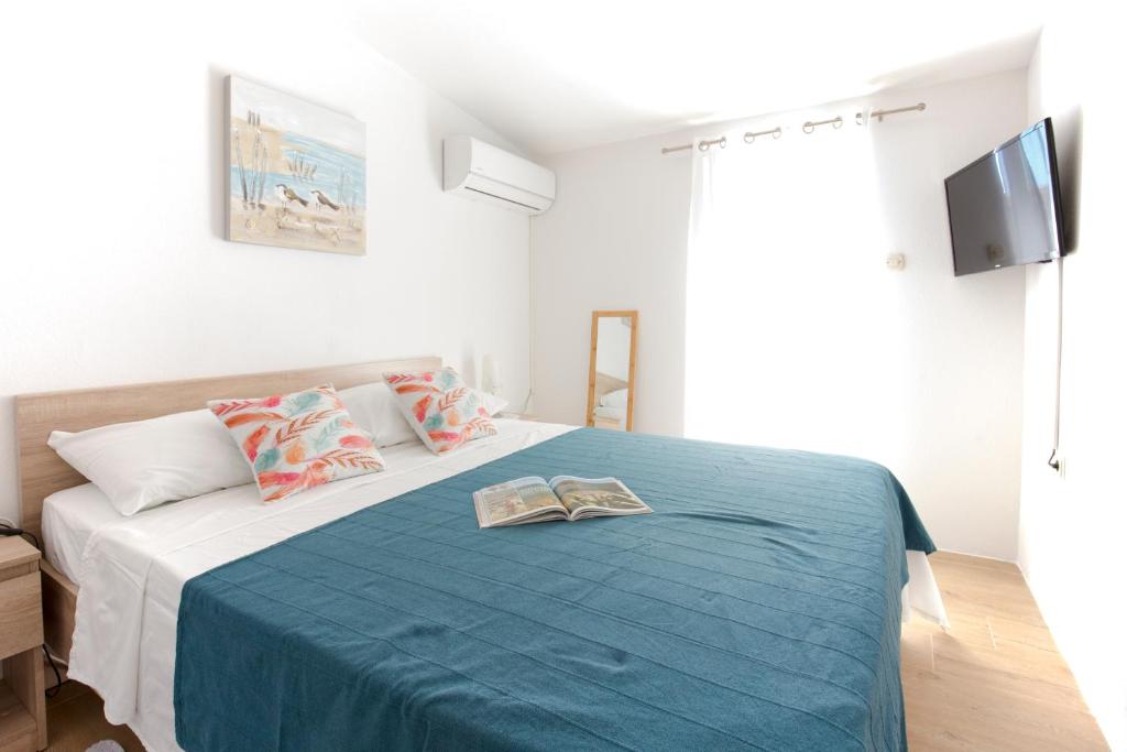 a bedroom with a bed with two books on it at Apartman Sara-Vis in Vis