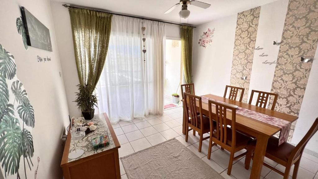 a kitchen and dining room with a table and chairs at Anthea Gardens - Cosy Condo in Paphos