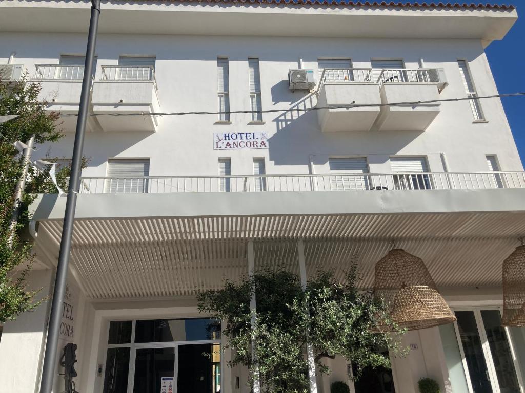 拉卡勒塔的住宿－Hotel L'Ancora，白色的建筑,上面标有读n hotel margaux的标志