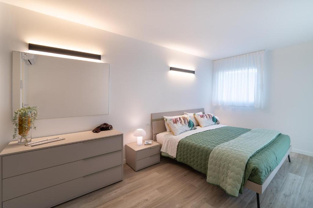 a bedroom with a bed and a dresser and a window at Zero5.Zero5 in Lignano Sabbiadoro