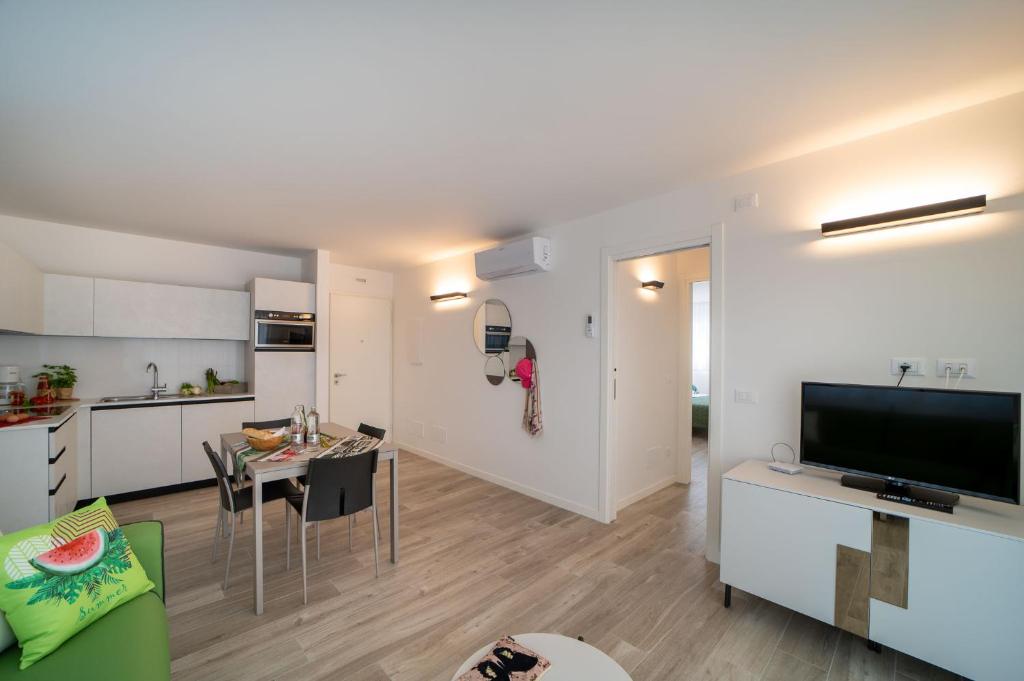 a living room with a kitchen and a dining room at Zero5.Zero5 in Lignano Sabbiadoro