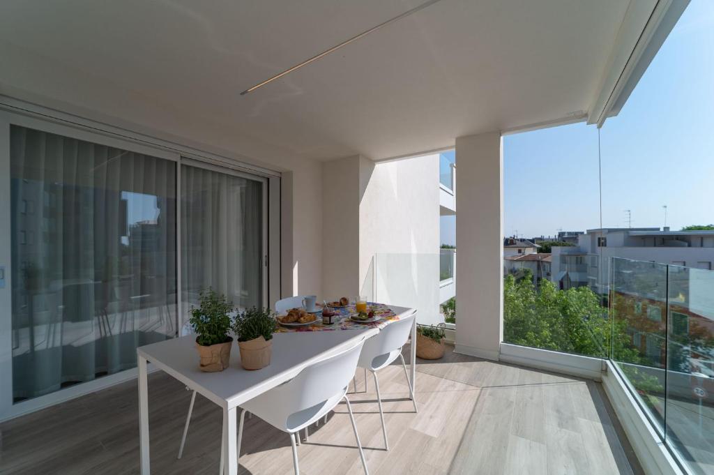 a white table and chairs on a balcony with a view at Zero5.Zero5 in Lignano Sabbiadoro