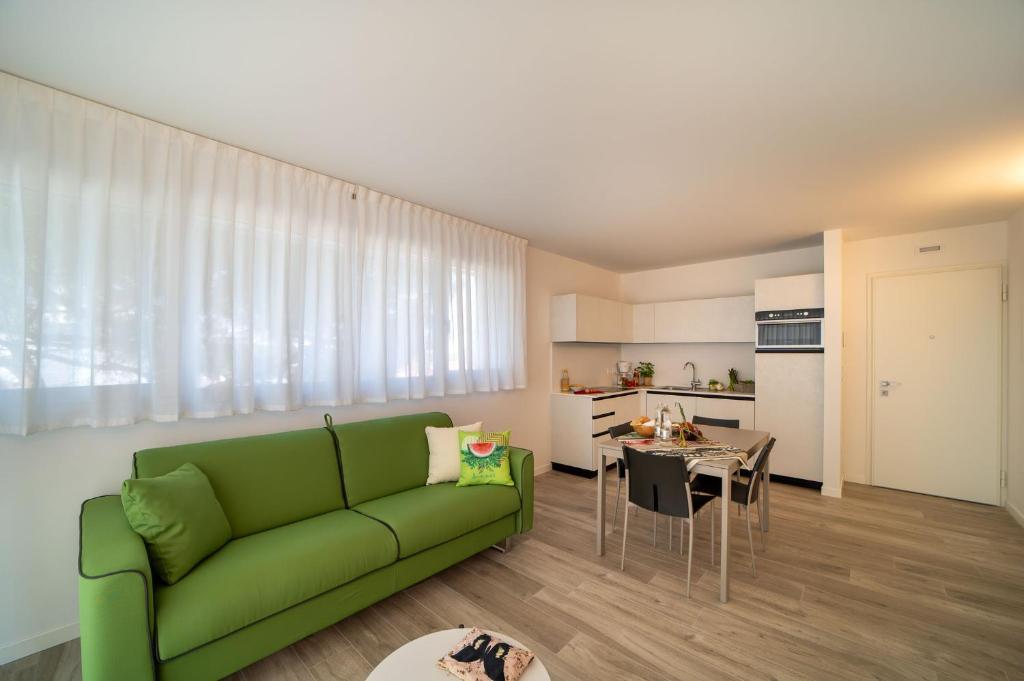 a living room with a green couch and a table at Zero5.Zero5 in Lignano Sabbiadoro