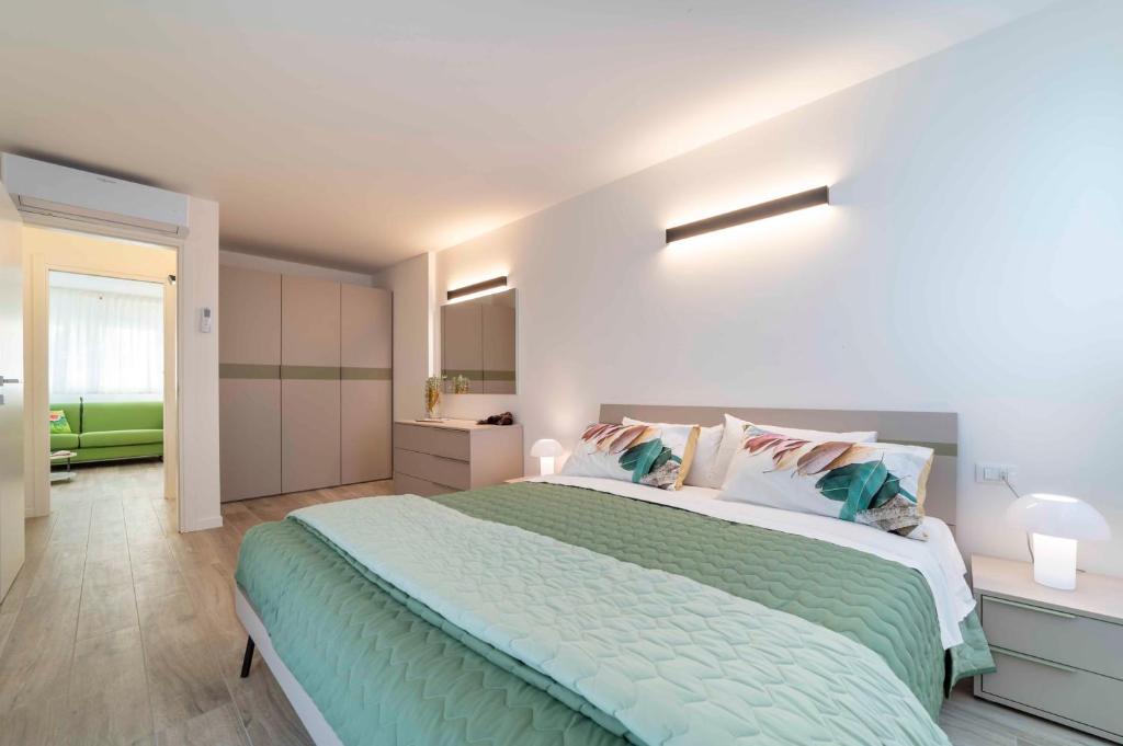 a bedroom with a large bed with a green comforter at Zero5.Zero5 in Lignano Sabbiadoro
