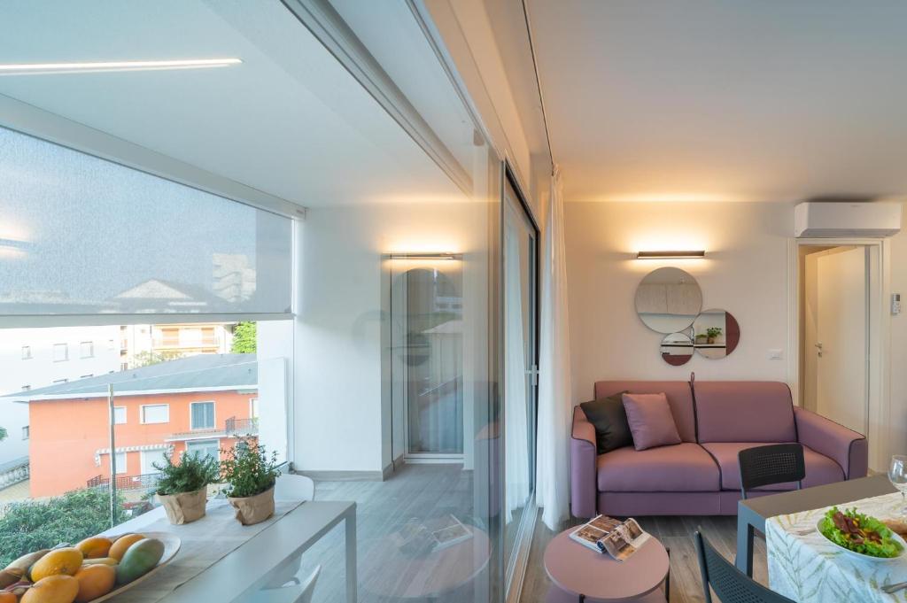 a living room with a purple couch and a window at Zero5.Zero5 in Lignano Sabbiadoro