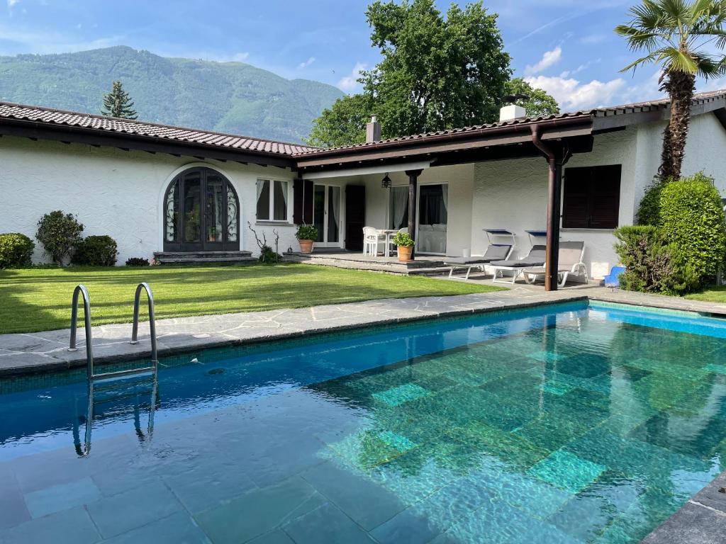 uma piscina em frente a uma casa em Casa Via Saleggi 10 em Ascona