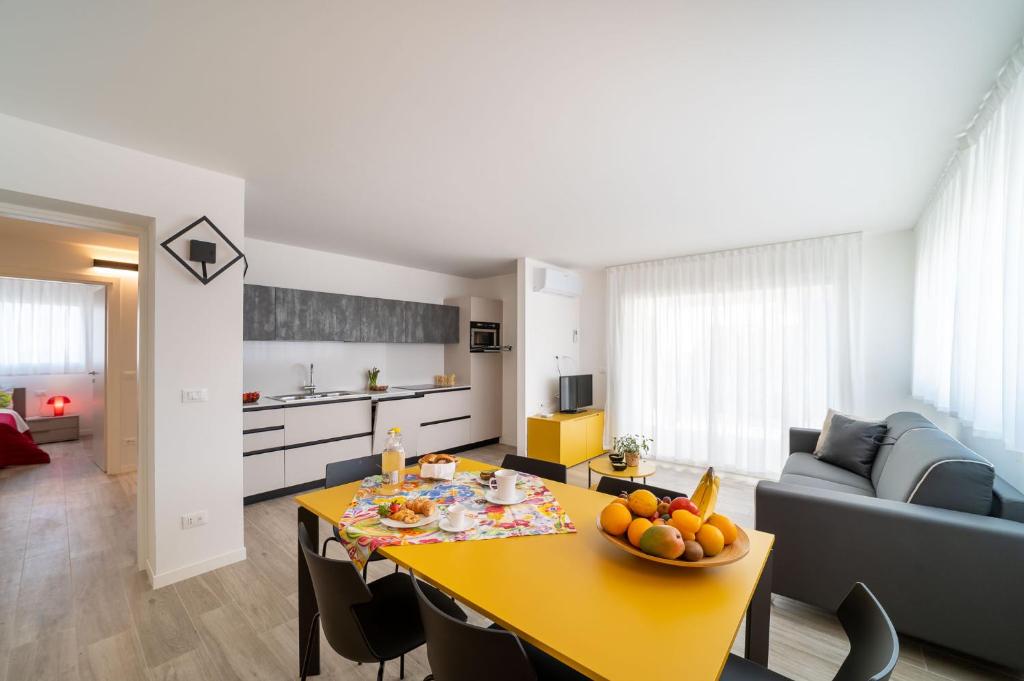 a kitchen and living room with a table and a couch at Zero5.Zero5 in Lignano Sabbiadoro