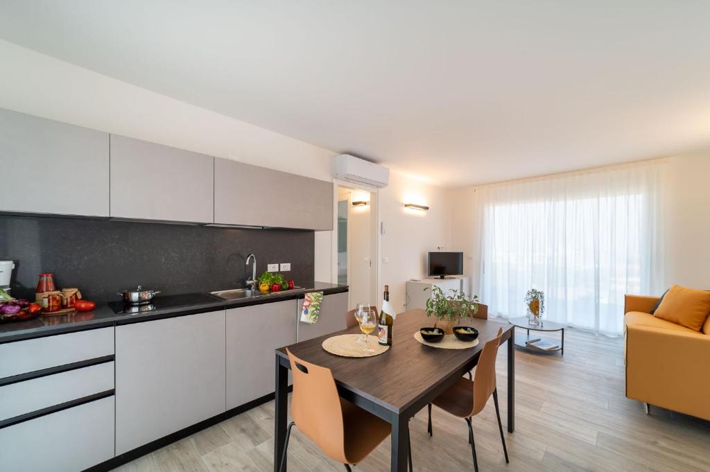 a kitchen and a dining room with a table in a room at Zero5.Zero5 in Lignano Sabbiadoro