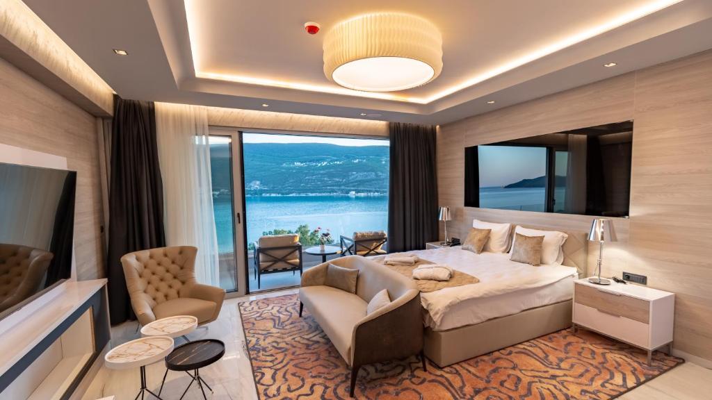 ein Schlafzimmer mit einem großen Bett und einem großen Fenster in der Unterkunft Garni Hotel Kruso in Herceg-Novi