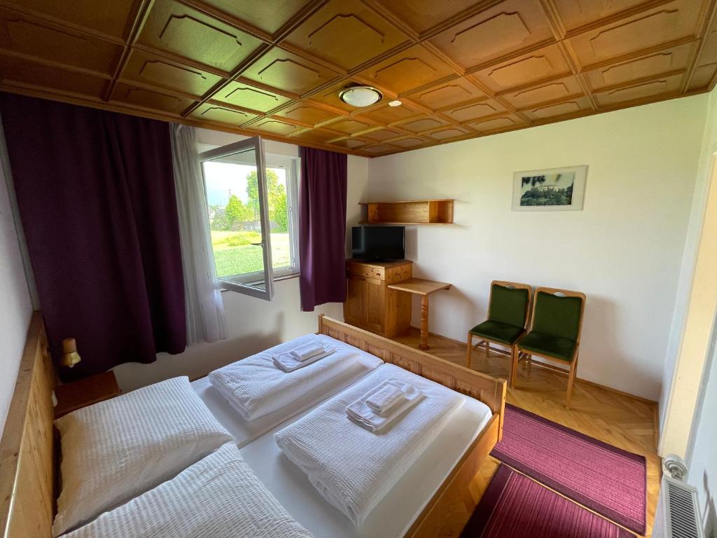 ein Schlafzimmer mit einem Bett und zwei Stühlen darin in der Unterkunft Rosental Apartments Self Check-in in Ferlach