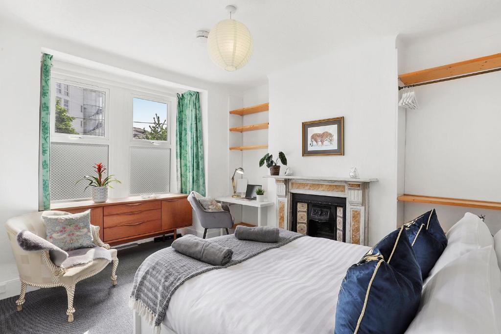 um quarto com uma cama grande e uma secretária em Stunning Victorian property near Canary Wharf! em Londres