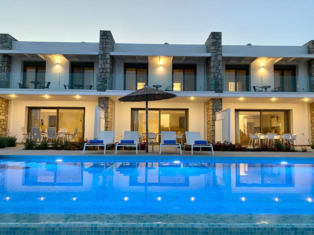 a villa with a swimming pool at night at Gennadi Harmony Suites - 200 m from the sea in Gennadi