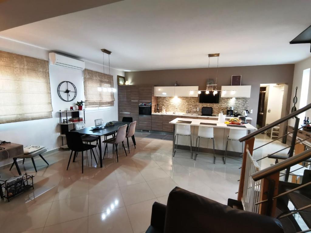 uma cozinha e sala de estar com mesa e cadeiras em KEY POINT Town House em Corfu Town