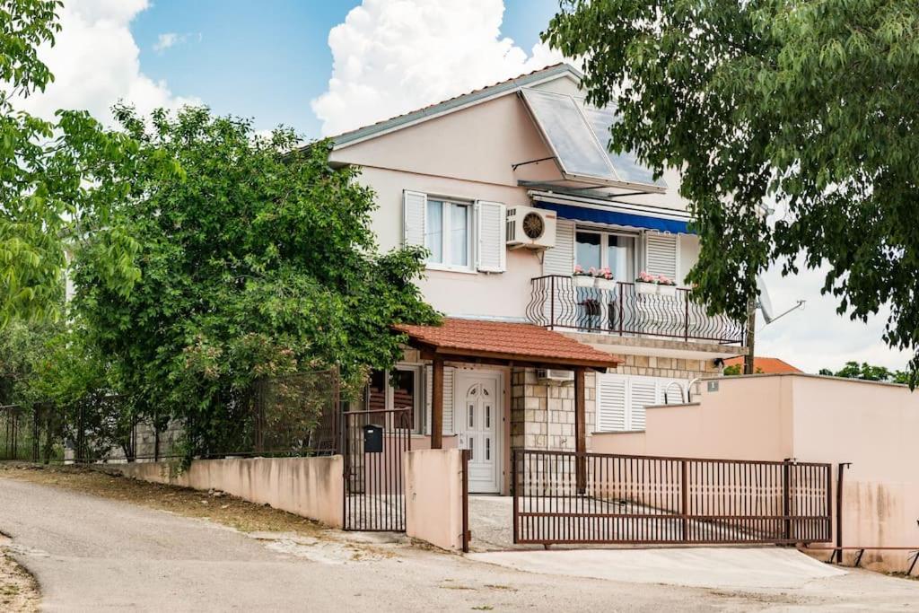 ein weißes Haus mit einem Zaun davor in der Unterkunft Holiday home Goranka in Zmijavci