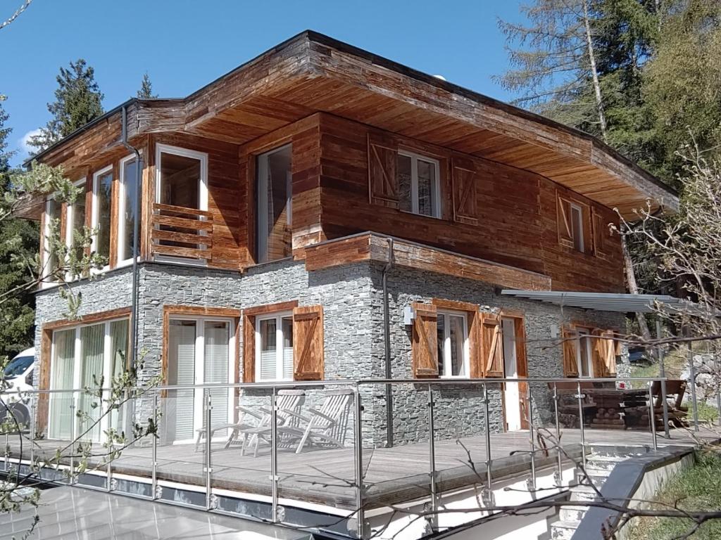 ein Haus, das mit einer Veranda und einem Haus gebaut wird in der Unterkunft Ferienhaus Skiblume in Oetz