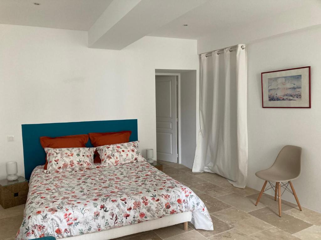 1 dormitorio con 1 cama y 1 silla en Maison Delière en Venterol