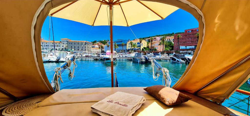une tente avec vue sur un port de plaisance avec des bateaux dans l'établissement La Ornella - Location bateau à quai de Thierry Bourgait, à Banyuls-sur-Mer