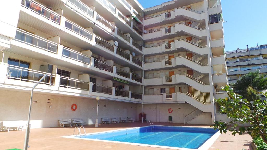 an apartment building with a swimming pool in front of it at DIFFERENTFLATS Decathlon in Salou