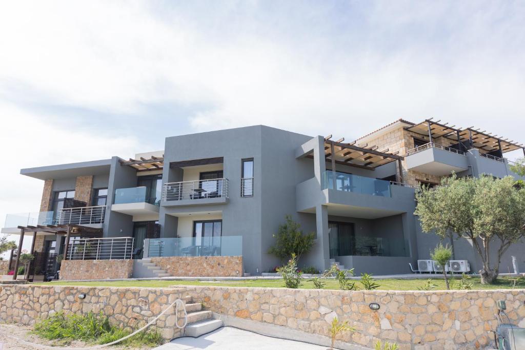 an image of a house with a stone wall at Tramonto Suites in Xi