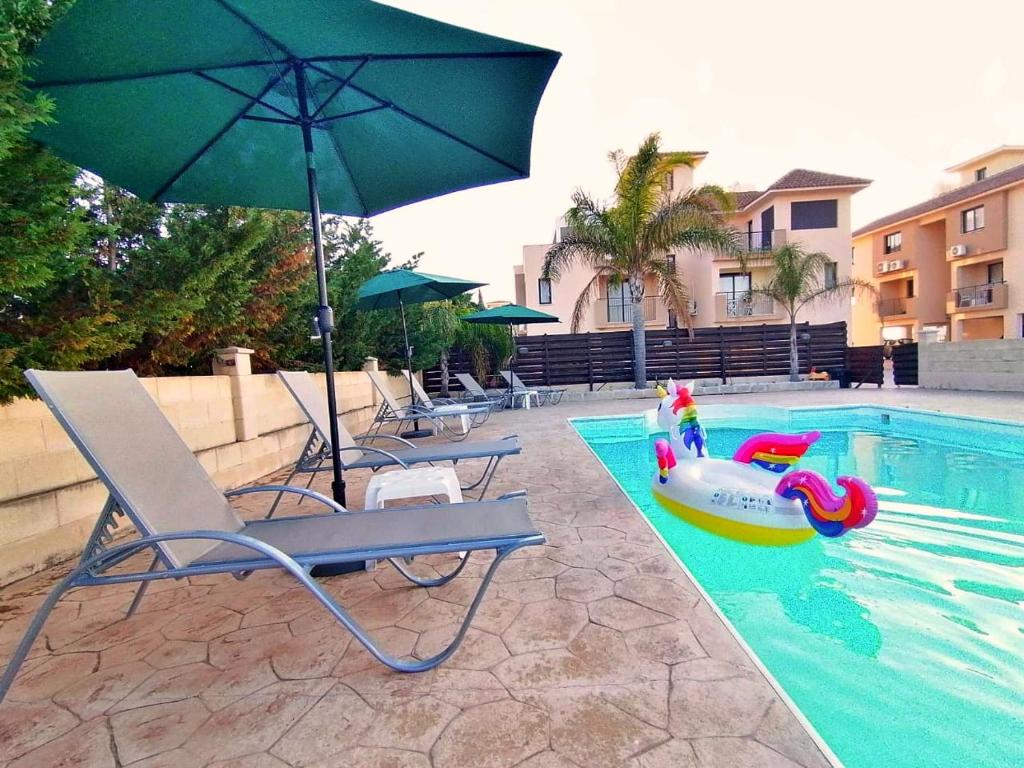 a pool with a chair and an umbrella and a raft at Afroditi Apartment in Perivolia