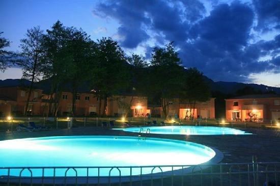 dwa duże baseny oświetlone w nocy w obiekcie Jolie appart. 4 pers. Dans résidence avec piscine w mieście Santa-Maria-Poggio