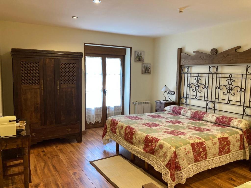 a bedroom with a bed and a wooden floor at B&B El Caminero in Hospital de Órbigo