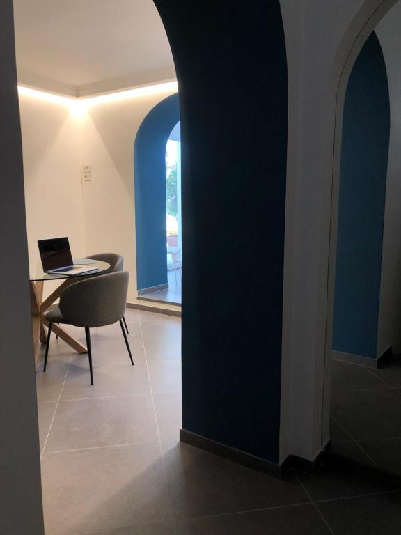 Casa Flavia في اناكابري: غرفة مع طاولة وكرسي وجهاز كمبيوتر محمول