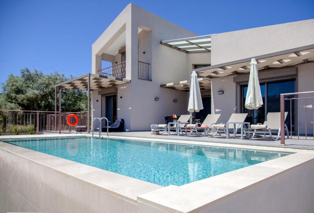 een villa met een zwembad en een huis bij VILLA ALKISTIS in Lefkada