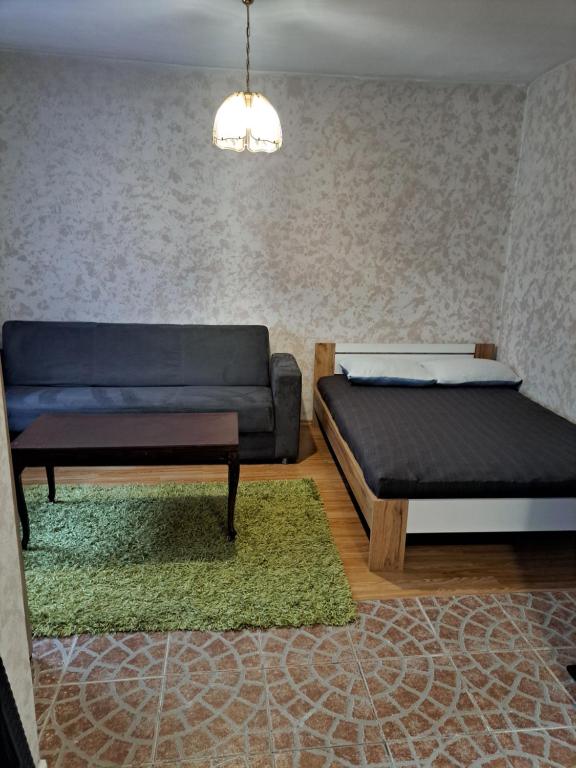 een woonkamer met 2 bedden en een bank bij Dobar san in Zagreb