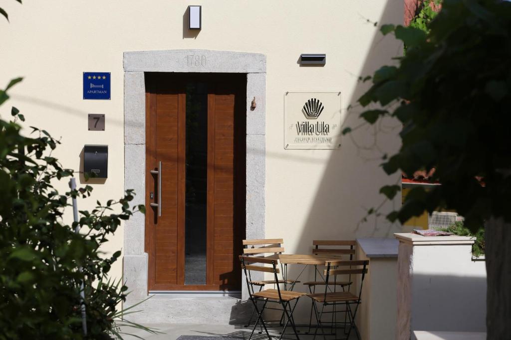 un edificio con sedie e porta in legno di Premium Apartments Villa Ula,Free Private PARKING a Opatija