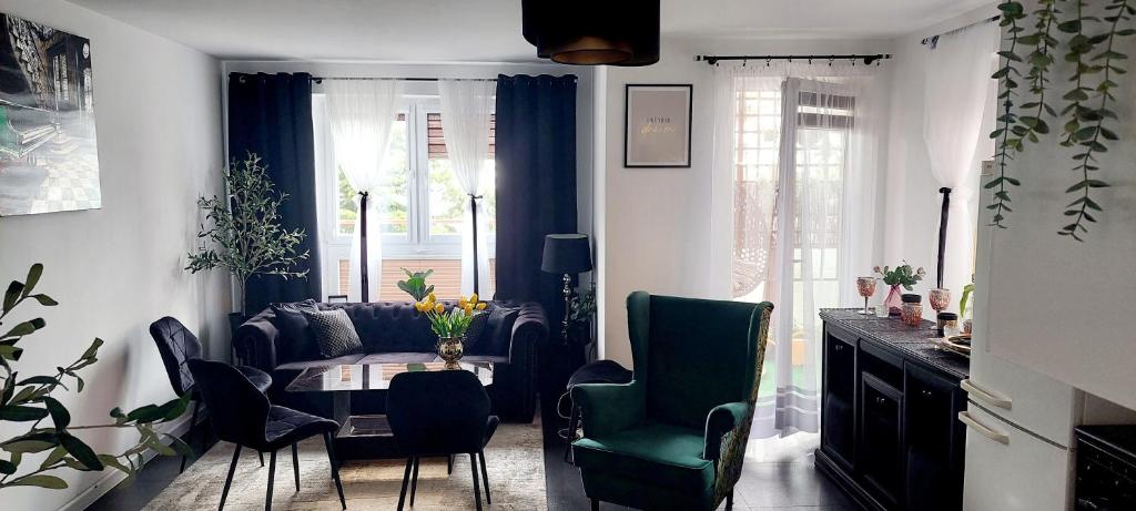 uma sala de estar com um sofá, uma mesa e cadeiras em Apartamenty Magvel em Szczecin