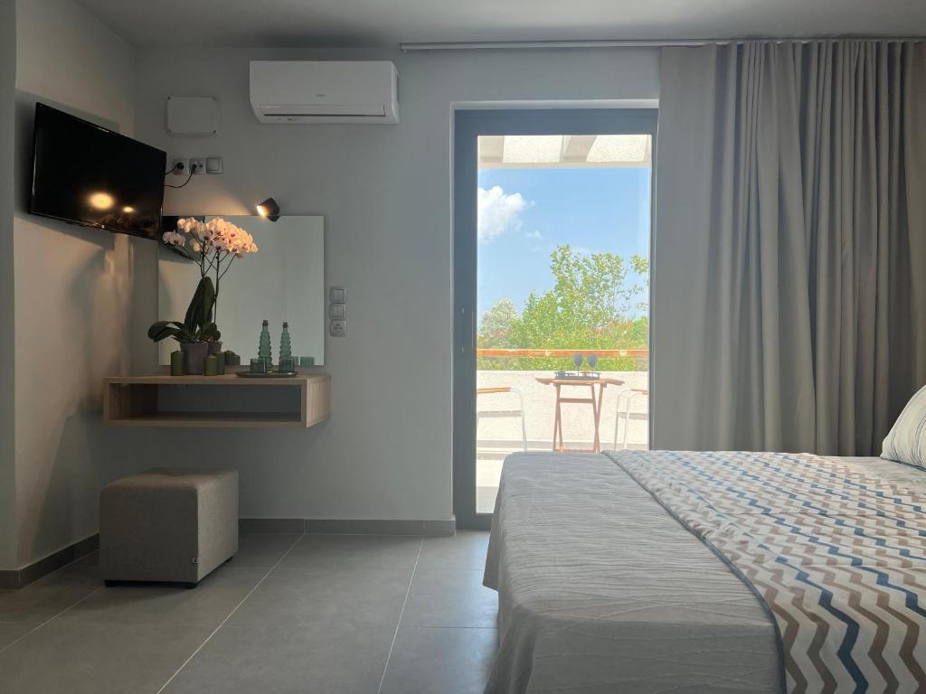 a bedroom with a bed and a view of a patio at Κimiro Hotel Tsilivi in Planos