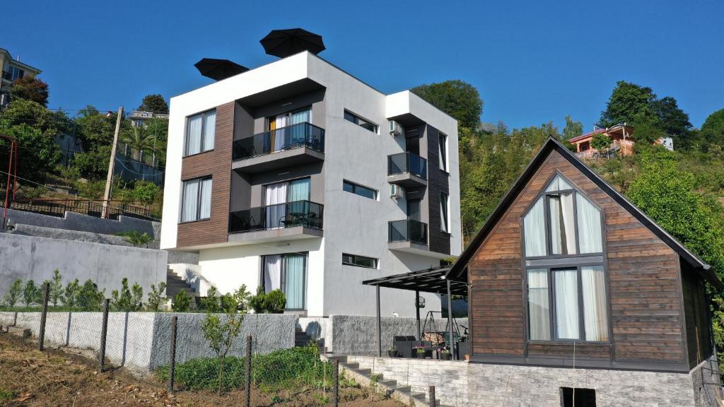 una casa en la cima de una colina con un edificio en Sleep and Wine en Batumi