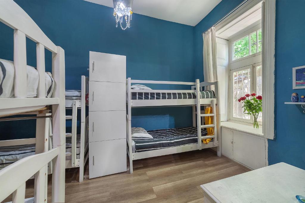 Una habitación con literas y una pared azul. en Doki House, en Tiflis