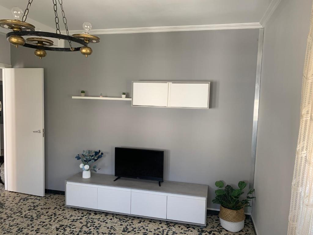 sala de estar con TV en una pared blanca en Apt Sueiras, en Burela de Cabo