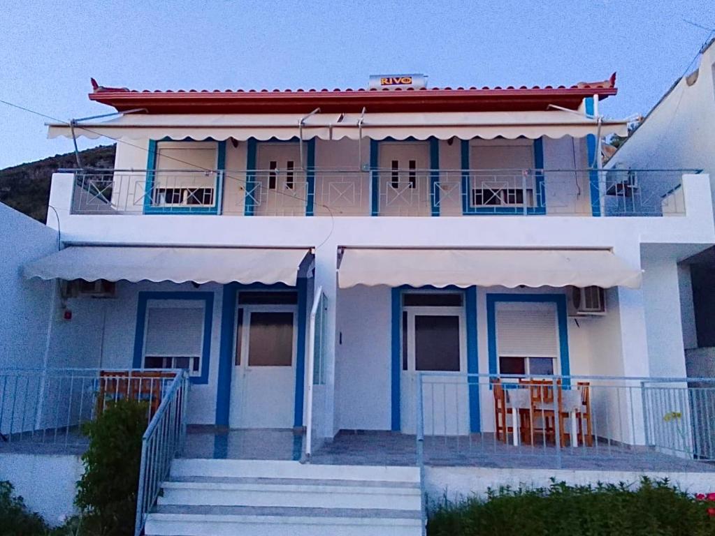Casa blanca con adornos azules y sillas en el balcón en Vila Gusti, en Borsh