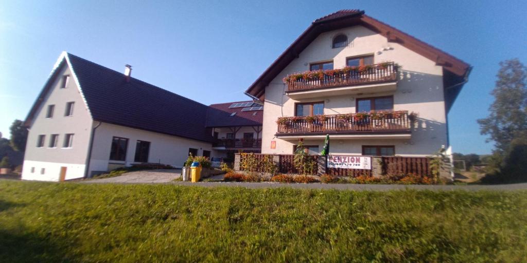 a large white house with a sign in front of it at Chalupa u pramene in Králíky