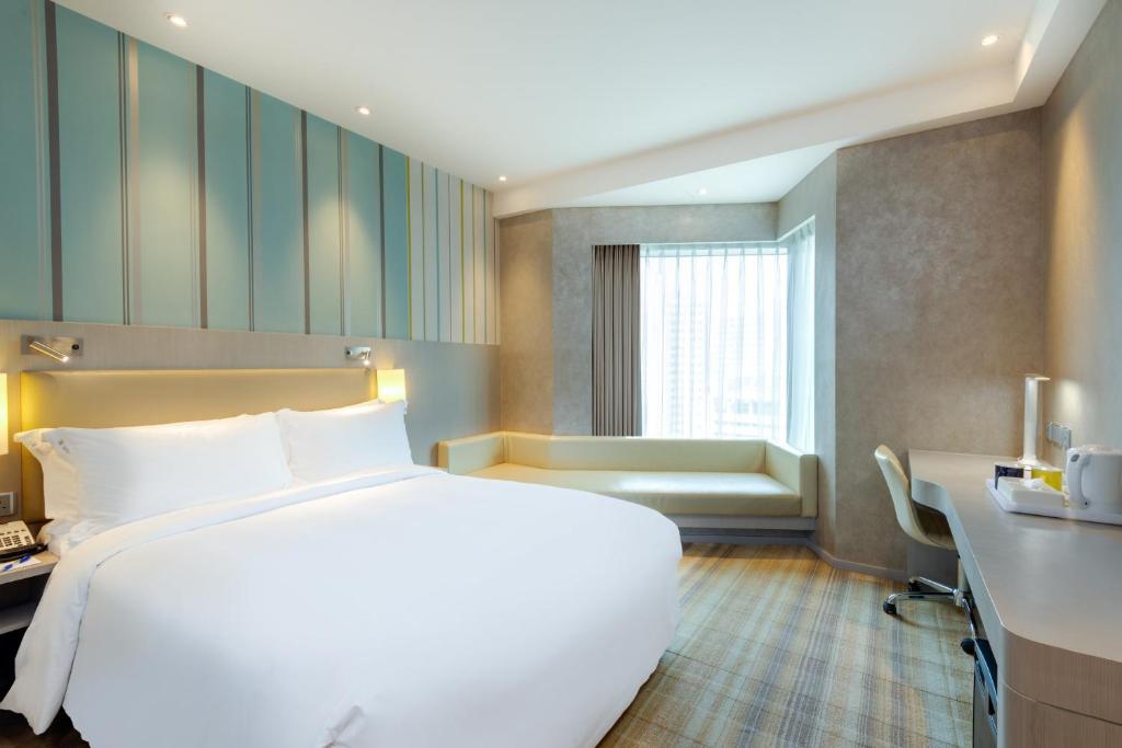 Holiday Inn Express Hong Kong Mongkok, an IHG Hotel tesisinde bir odada yatak veya yataklar