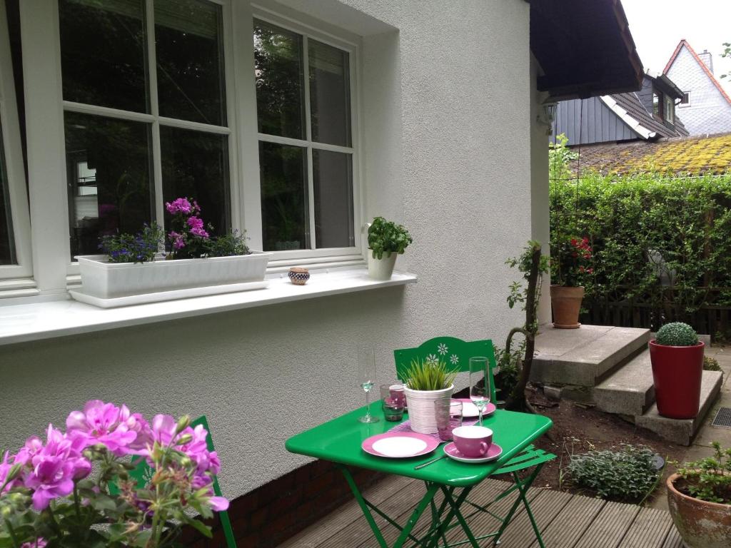 a green table and chairs on a porch with flowers at Apartment Base in Hamburg