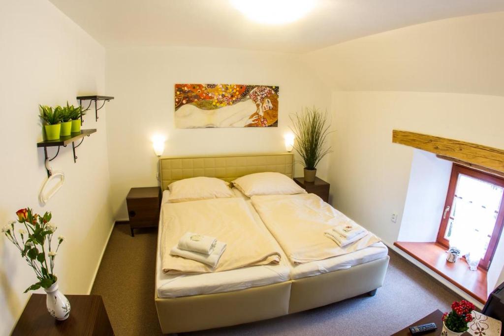 1 dormitorio con 1 cama y una pintura en la pared en Hotel Hospodářský dvůr Bohuslavice en Telč
