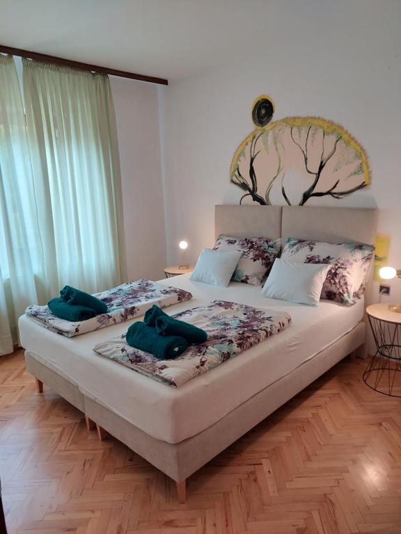 una camera da letto con un letto con due asciugamani verdi di Apartman Marija II a Omišalj (Castelmuschio)