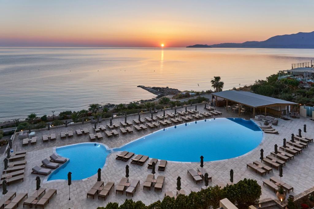 eine Luftansicht eines Resorts mit Pool und Stühlen in der Unterkunft Blue Marine Resort and Spa Hotel in Agios Nikolaos